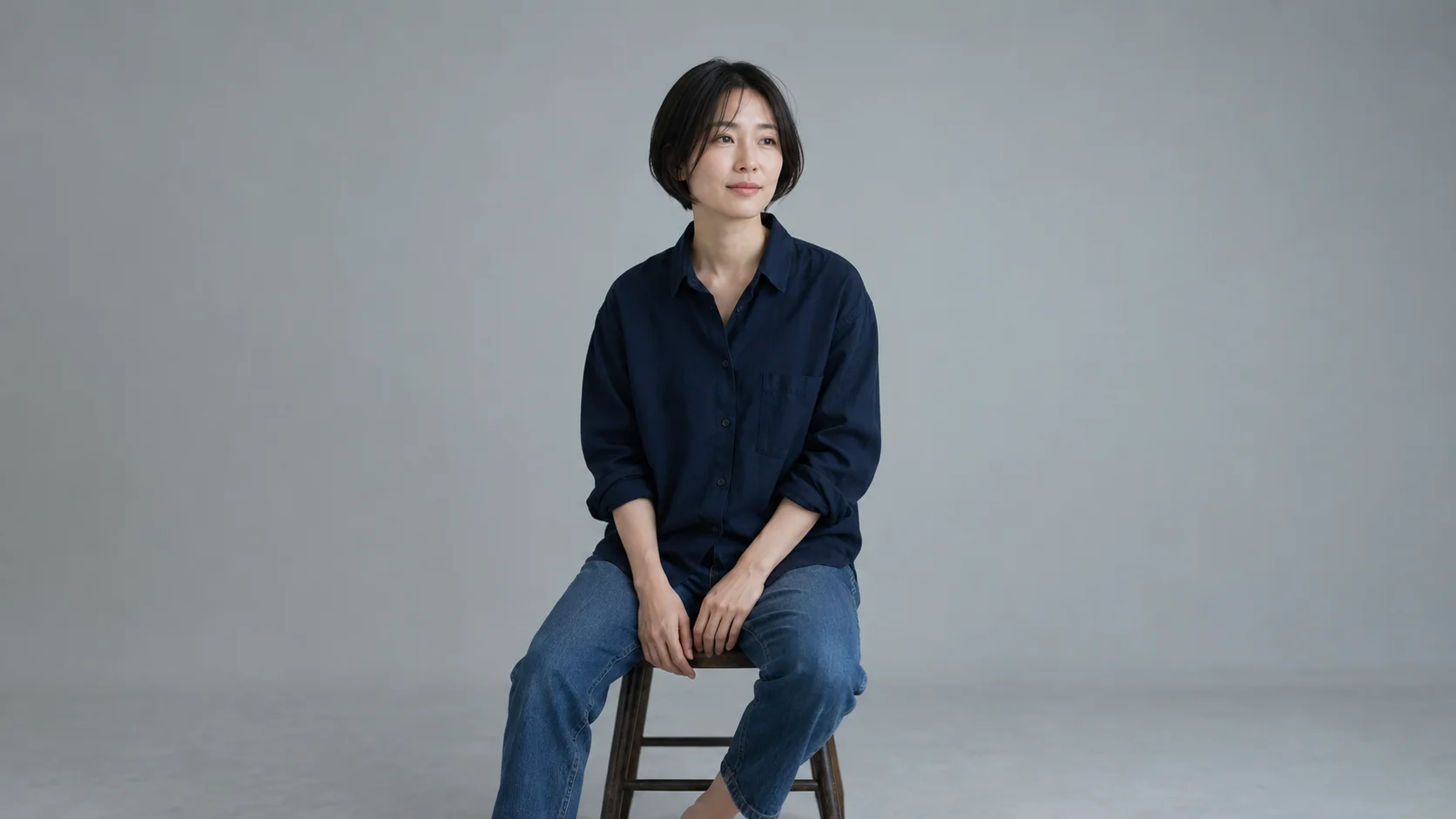 柔らかな光の中、自然なボブヘアで腰かける女性のイメージ